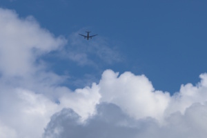 Flugzeug am Himmel, weiße Wolken.
