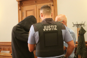 Angeklagtem werden handfesseln abgenommen.