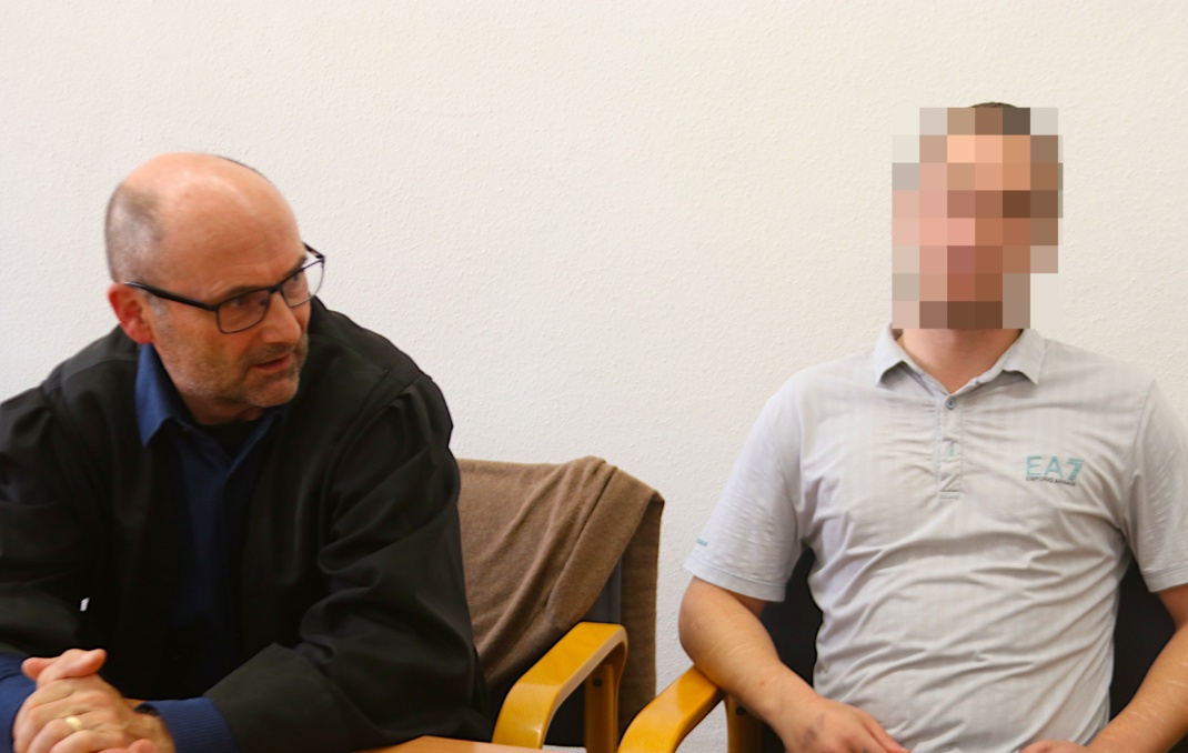 Angeklagter sitzt neben seinem Anwalt im Gerichtssaal.