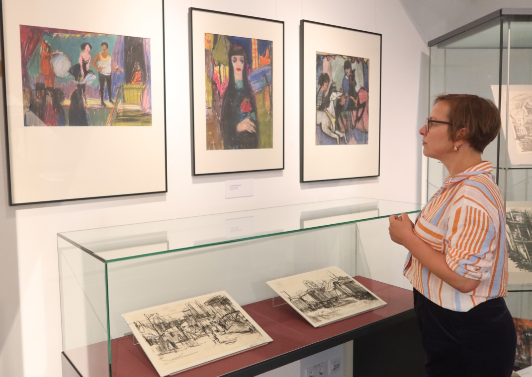 Drau steht vor einer Gemäldesammlung.