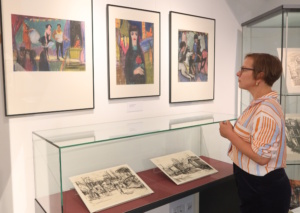 Drau steht vor einer Gemäldesammlung.