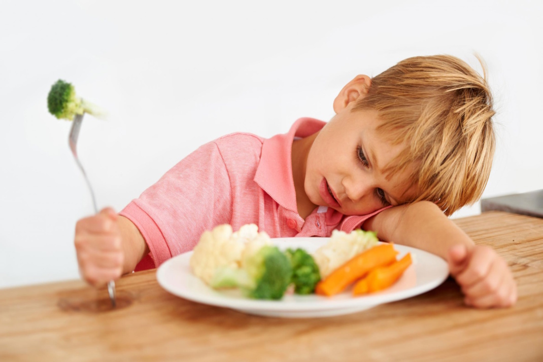 Kind vor gefülltem Teller.