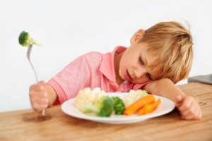 Kind vor gefülltem Teller.