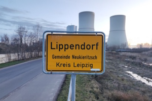 Ortsschild zu Lippendorf, Türme des Kraftwerks im Hintergrund.