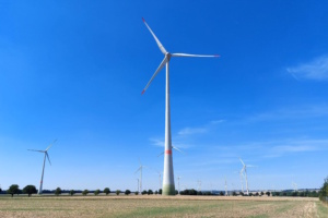 Windkraftanlagen auf freiem Feld, blauer Himmel.