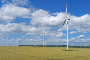 Windkraftanlagen auf freiem Feld, Wolken und blauer Himmel.