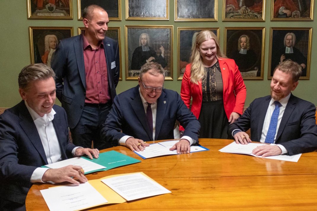 Wissenschafts-Staatssekretär Thomas Wünsch (Sachsen-Anhalt), Ministerpräsident Mario Voigt (Thüringen) und Ministerpräsident Michael Kretschmer (Sachsen) unterzeichnen Absichtserklärung zur Förderung von iDiv über 2030 hinaus. Im Hintergrund Martin Quaas, wissenschaftlicher Geschäftsführer, und Anne Wesemann, administrative Geschäftsführerin von iDiv. Foto: Stefan Bernhardt