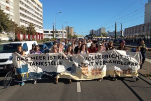 Klimastreik, junge Menschen marschieren mit Banner.