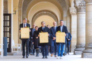 Der Trauerzug mit den symbolischen Särgen auf dem Weg zur Ruhestätte. V.l.n.r.: Prof. Martin Gericke, Institut für Anatomie, Romani Rose, Vorsitzender des Zentralrates deutscher Sinti und Roma, und Gjulner Sejdi, Vorsitzender von Romano Sumnal. Foto: Swen Reichhold/Universität Leipzig