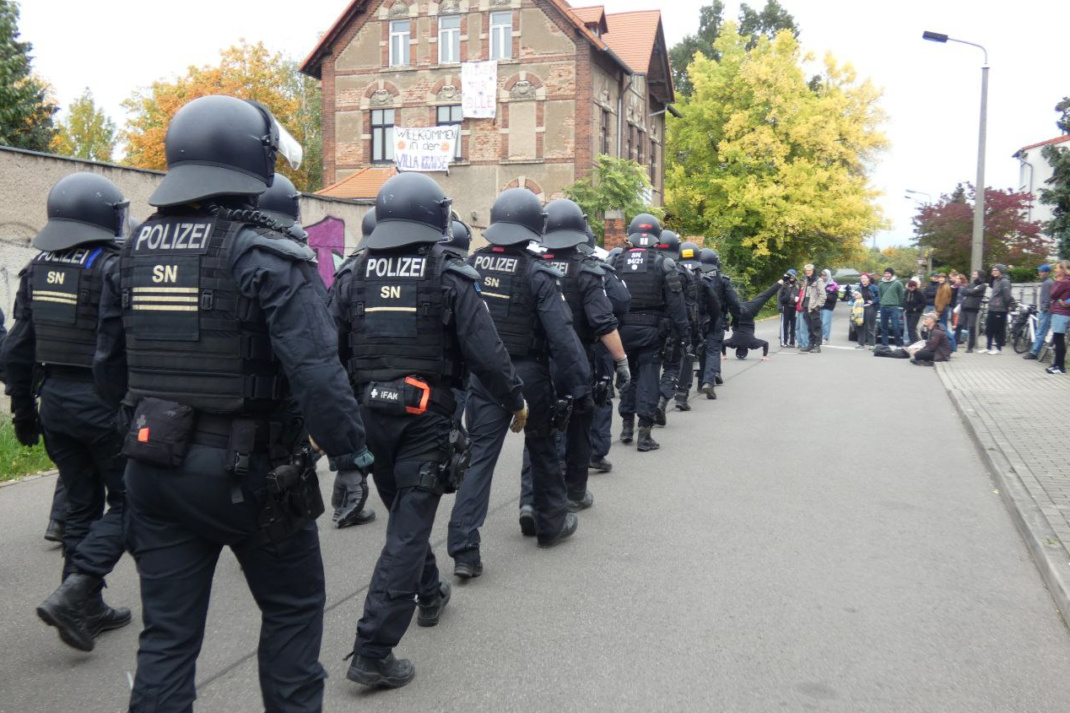Polizeieinheiten gehen eine Straße entlang.