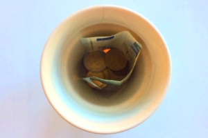 Mit Geld gefüllte Tasse von oben.