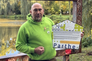 Axel Weinert mit Beschilderung für einen "Beau View"-Rahmen in Taucha. Foto: Stadt Taucha