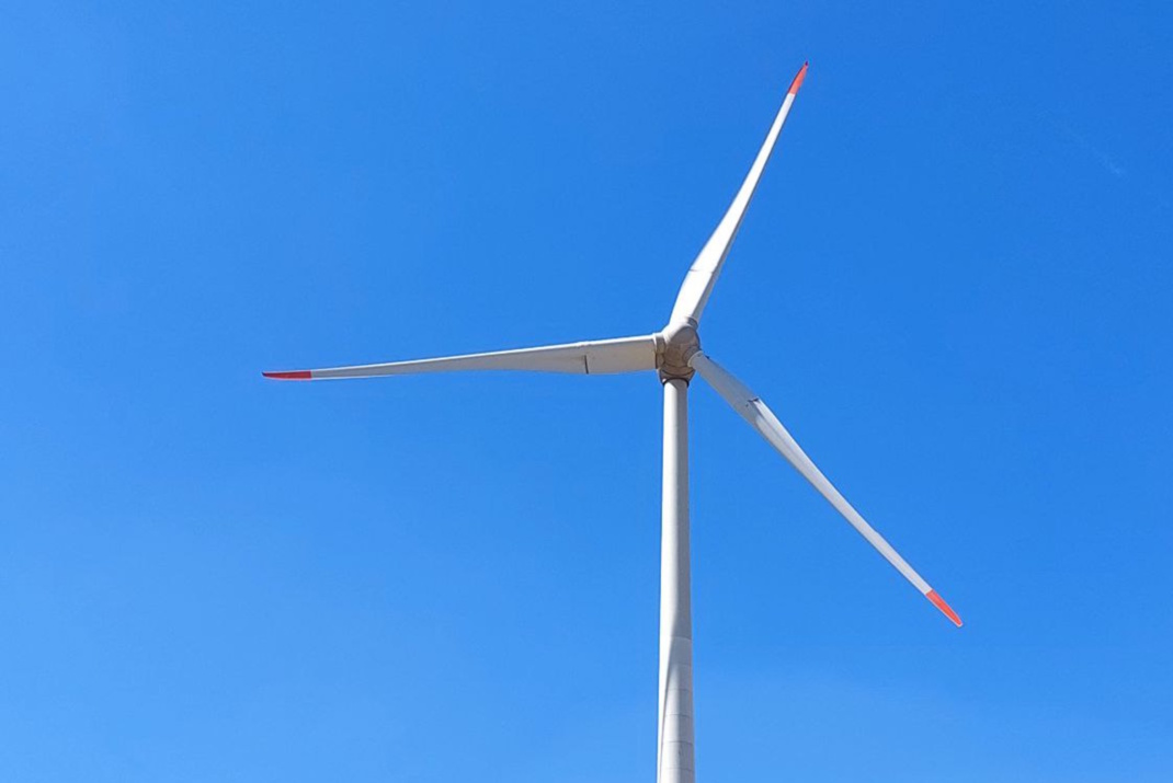 Windrad vor blauem Himmel.
