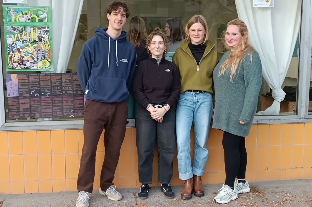 Personengruppe posiert am Schaufenster für ein Foto.