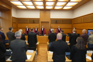 Gerichtssaal, Kläger und Beklagte, Richter in roten Roben.