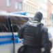 Vermummter Polizist an Polizeiwagen,