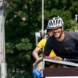 Mann mit weißem Helm auf Fahrrad.
