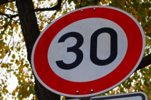 Nahaufnahme eines Tempo 30-Schildes von unten.