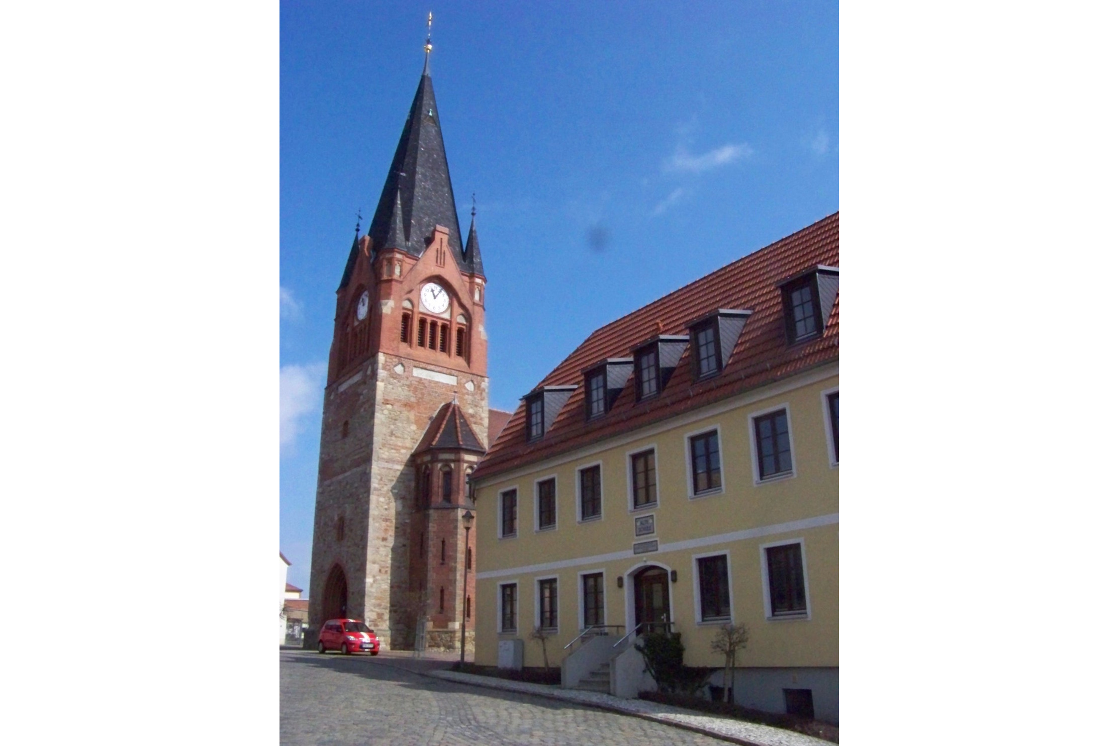 Kirchturm und benachbarte “Alte Schule” (Tnemtsoni, CC BY-SA 3.0, https://commons.wikimedia.org/w/index.php?curid=25576983)