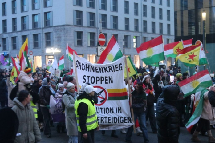 Menschenmenge mit Fahnen und Bannern