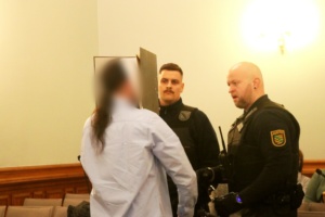 Angeklagter im Saal mit Wachtmeistern.