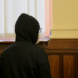 Angeklagter steht mit Kapuze im Gerichtssaal.