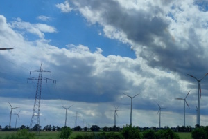 Windkraftanlagen und Überlandleitungen auf freiem Feld.