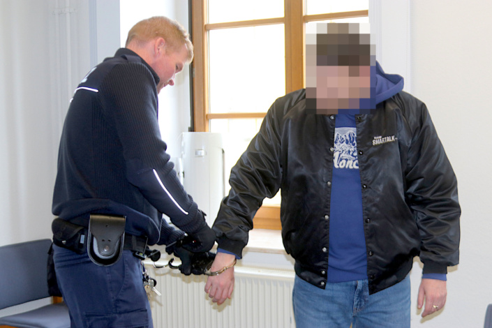 Ein Justizbeamter nimmt dem Angeklagten (37, re.) im Gerichtssaal die Handschellen ab. Foto: Lucas Böhme