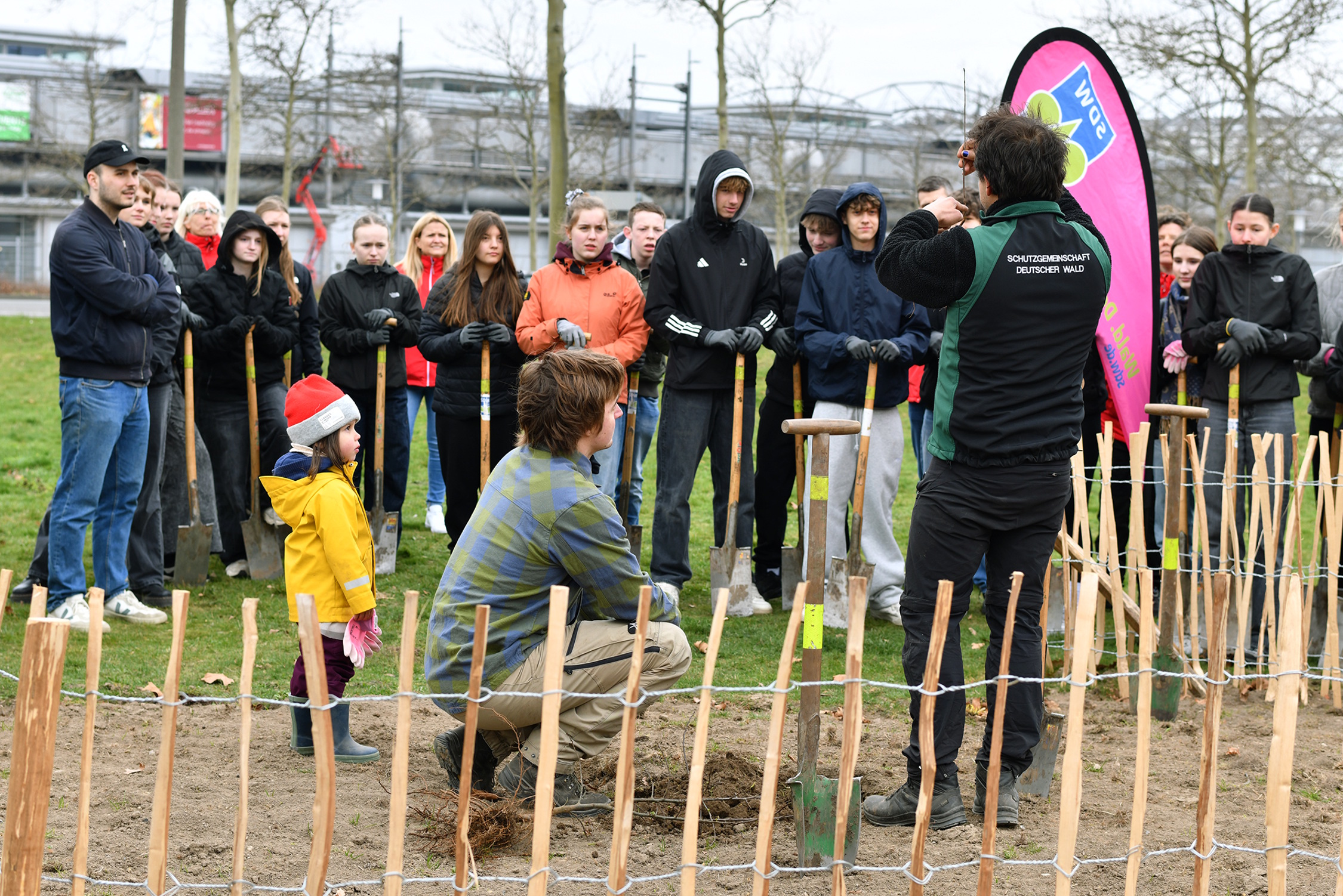 Die Baumexperten der SDW zeigen den Teilnehmenden, wie die Pflanzung funktioniert. Foto: BAUHAUS AG/Jenny Stadthaus