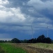 Dunkle Wolken, Windräder in Landschaft,