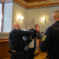 Justizbeamte nehmen Angeklagtem Handfesseln ab.