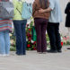 Menschen stehen vor Blumen und Kerzen und halten inne.