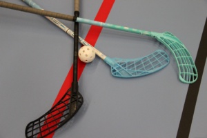 Drei Floorball-Schläger und ein Ball