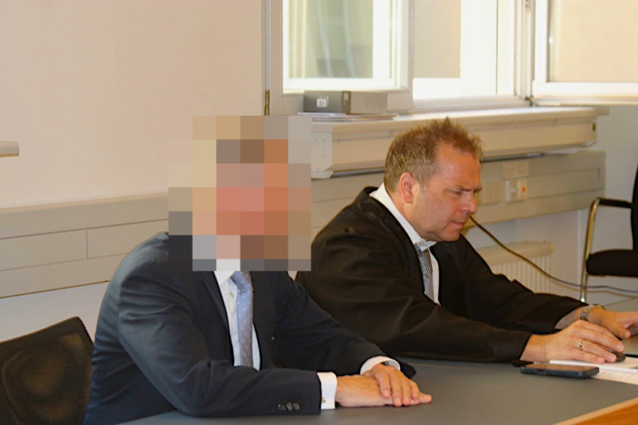 Mann mit unkenntlich gemachtem Gesicht sitzt neben seinem Verteidiger im Amtsgericht.