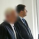 Prof. Strauß steht neben seinem Verteidiger als Angeklagter im Gerichtssaal.