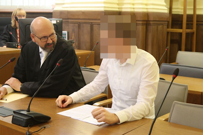 Angeklagter mit Anwalt im Gerichtssaal.