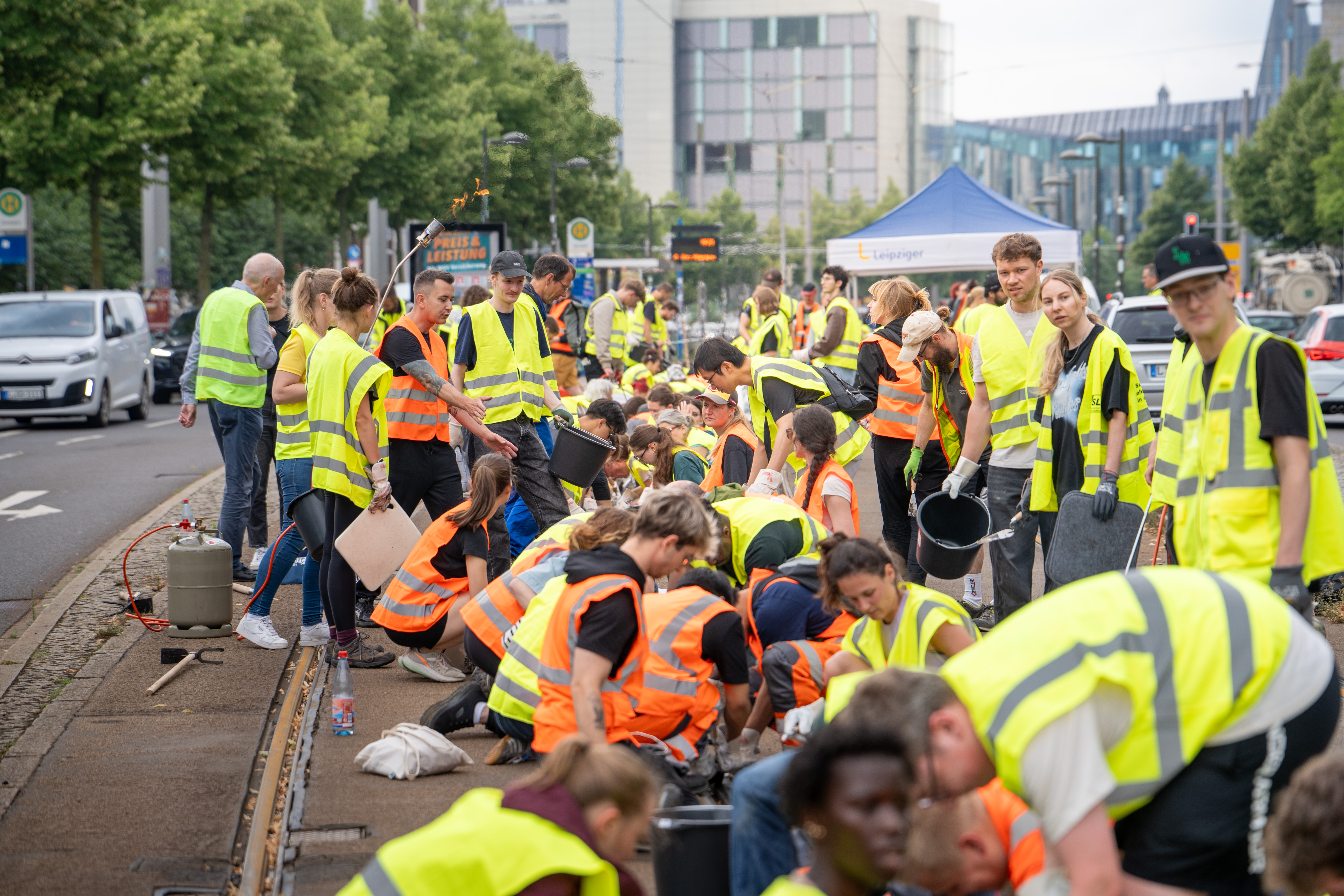 Freiwillige Helfer beim Entfernen der aufgequollenen Fugenmasse hier am Augustusplatz. Foto: LZ