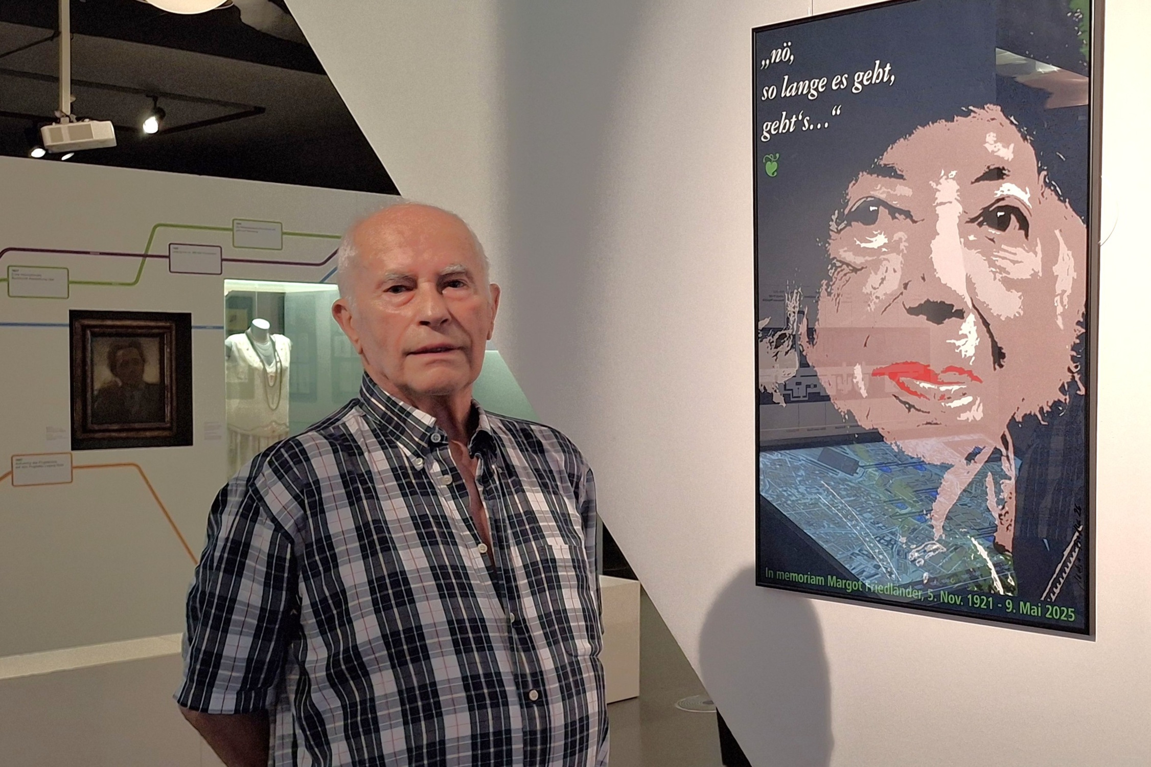 Jochen Fiedler in der Ausstellung im Alte Rathauis vor dem Plakat FRIED – LÄNDER. „Seid Menschen“.Margot Friedländer. Foto: Stadtgeschichtliches Museum