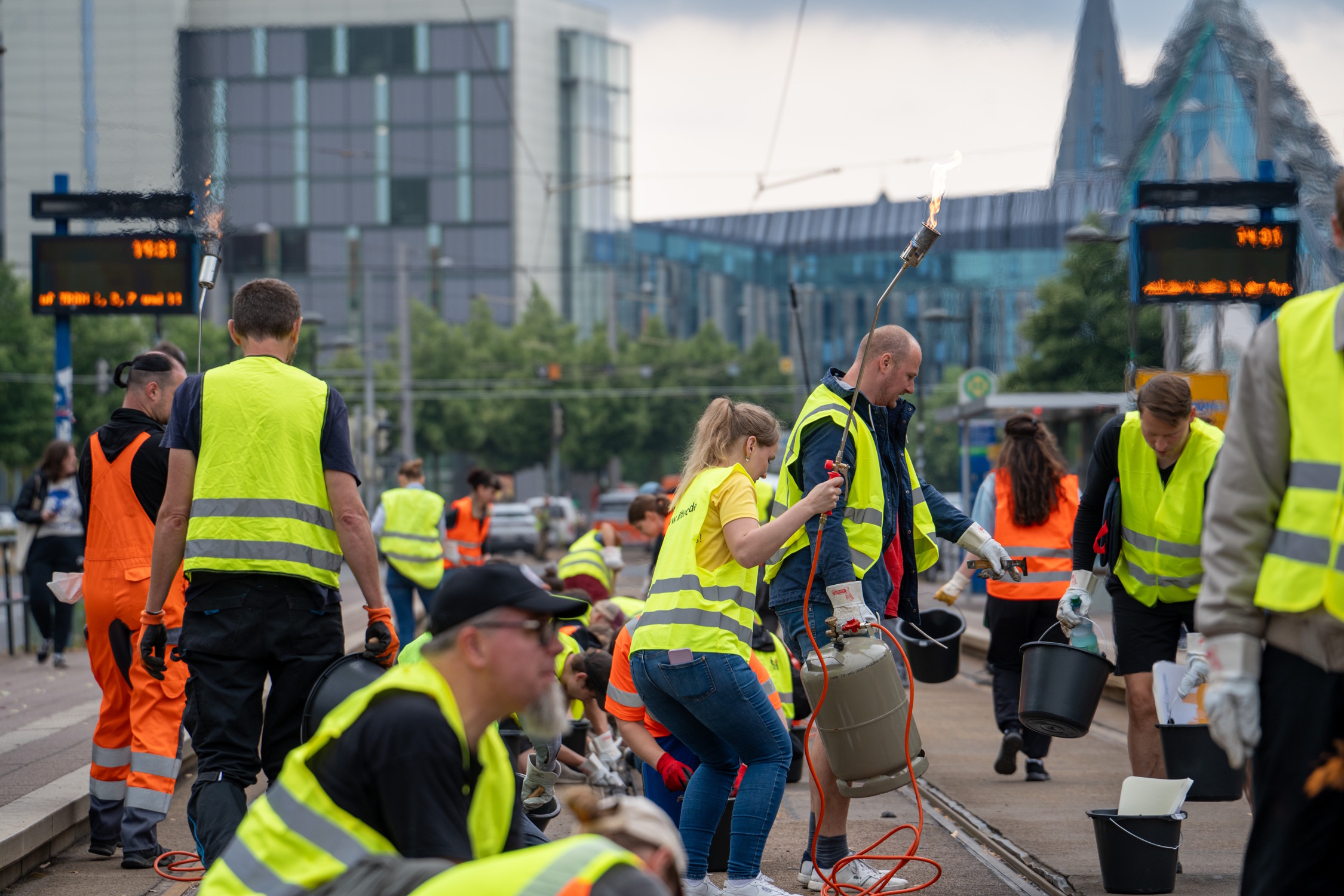 LVB-Mitarbeiter und Freiwillige bei der Beseitigung der Fugenmasse am Augustusplatz. Foto: Ferdinand Uhl